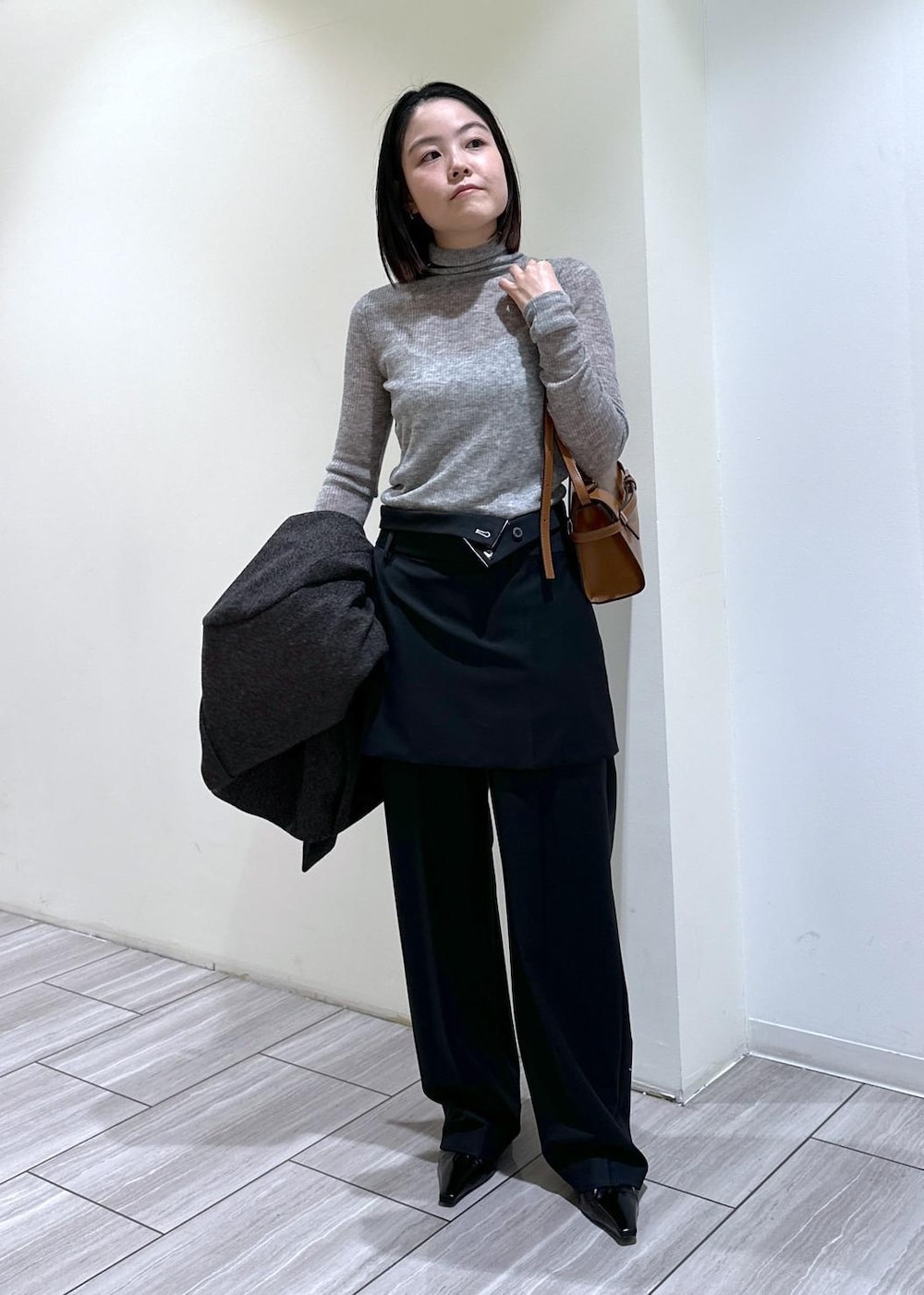 ブラック系のパンプス、グレー系のニット/セーター、ブラック系のスラックスを着用したレディースの秋コーディネートの4枚目の写真