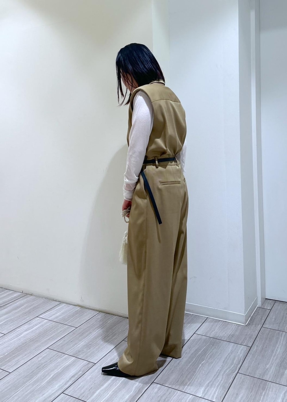 ホワイト系のショルダーバッグ、ベージュ系のサロペット/オーバーオール、ブラック系のパンプスを着用したレディースの秋コーディネートの2枚目の写真