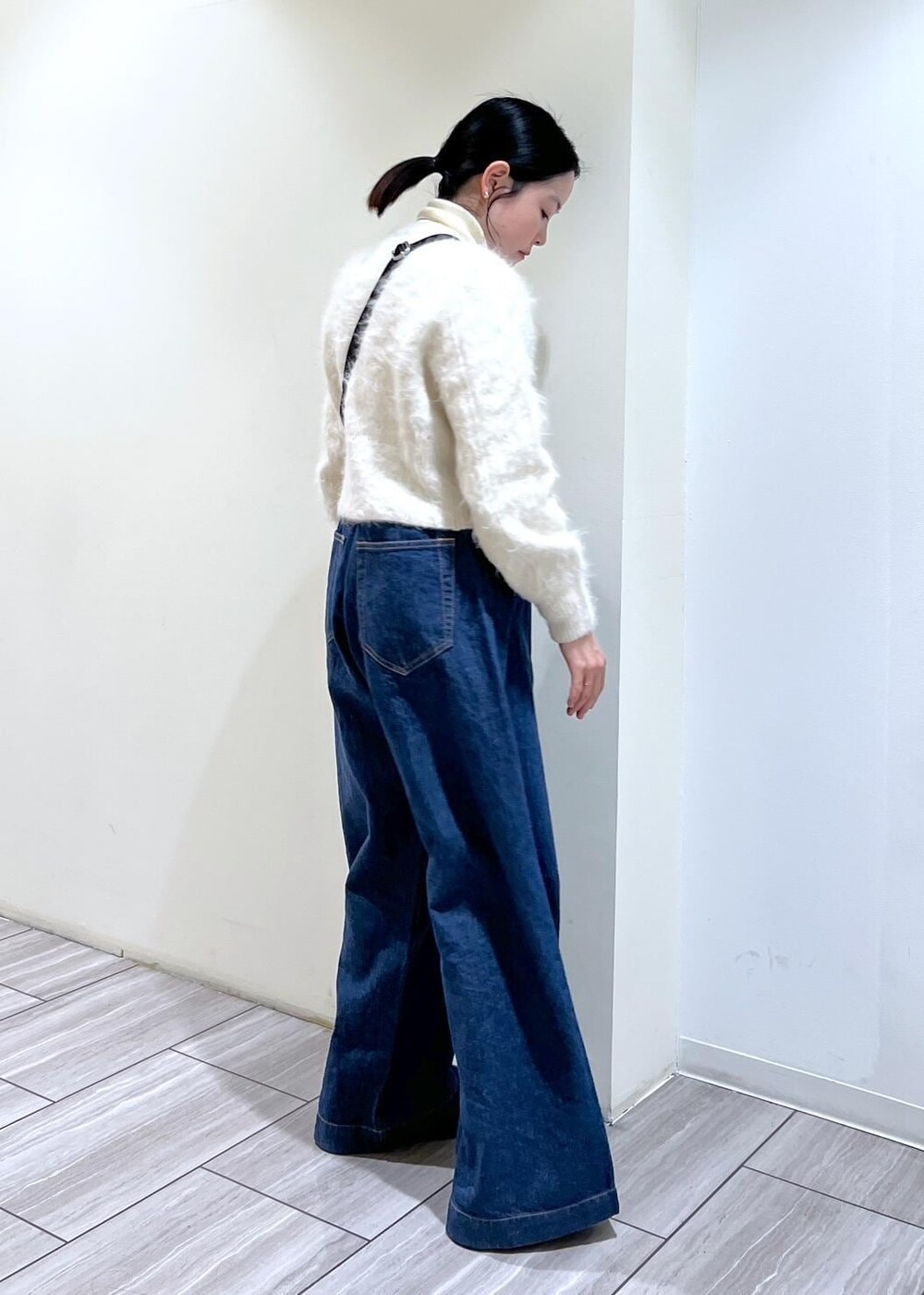 ベージュ系のトートバッグ、ブラック系のサンダル、ホワイト系のカーディガン/ボレロを着用したレディースの冬コーディネートの5枚目の写真