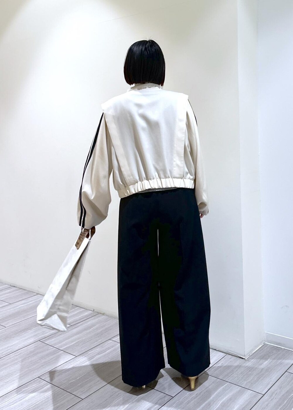 ゴールド系のその他シューズ、ホワイト系のブルゾン、グレー系のTシャツ/カットソーを着用したレディースの春コーディネートの5枚目の写真