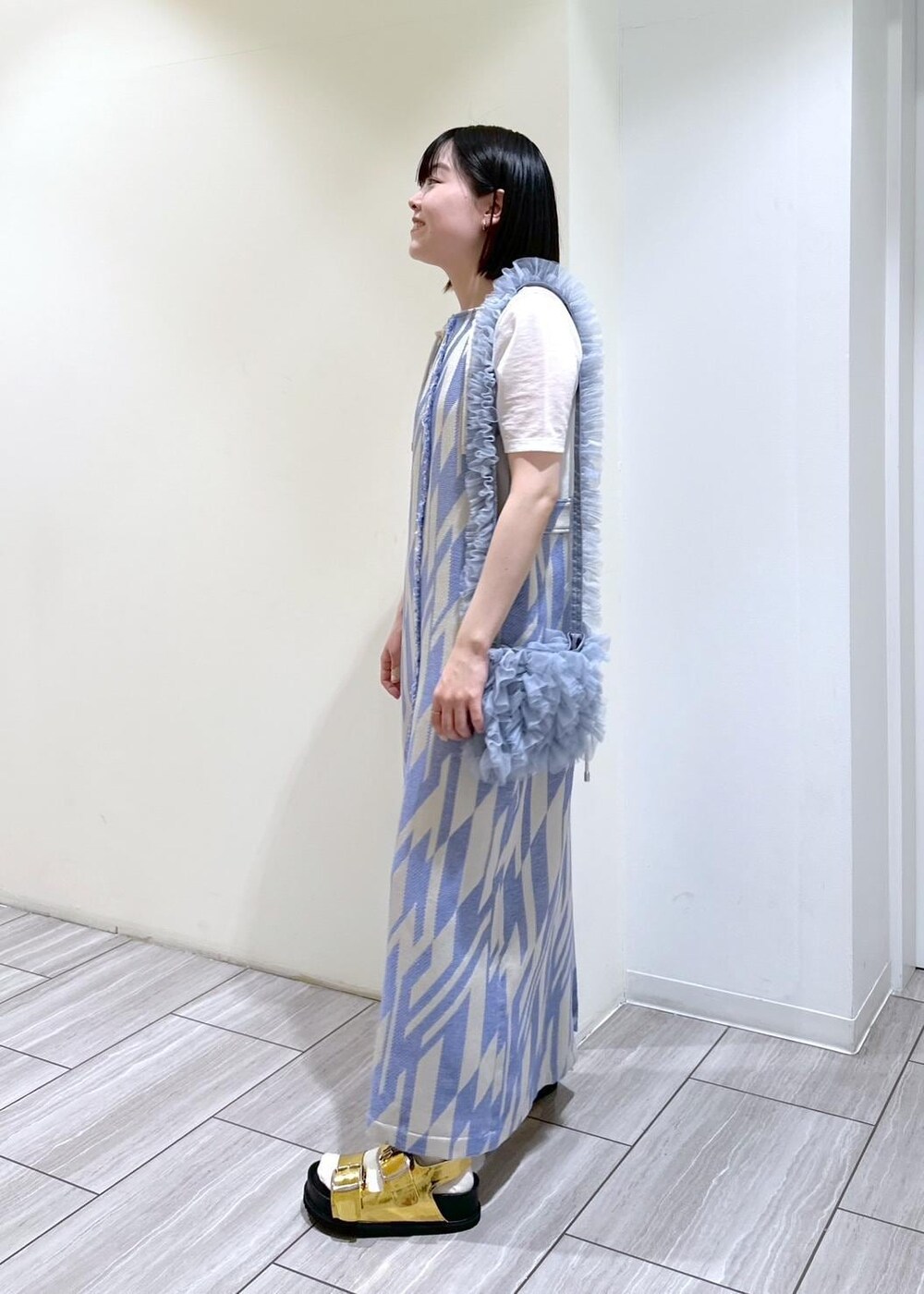 ゴールド系のサンダル、ホワイト系のTシャツ/カットソー、ブルー系のショルダーバッグを着用したレディースの春コーディネートの3枚目の写真