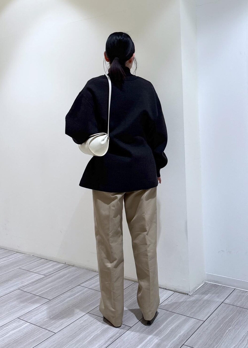 ブラック系のパンプス、グレー系のカーディガン/ボレロ、ホワイト系のショルダーバッグを着用したレディースの冬コーディネートの4枚目の写真