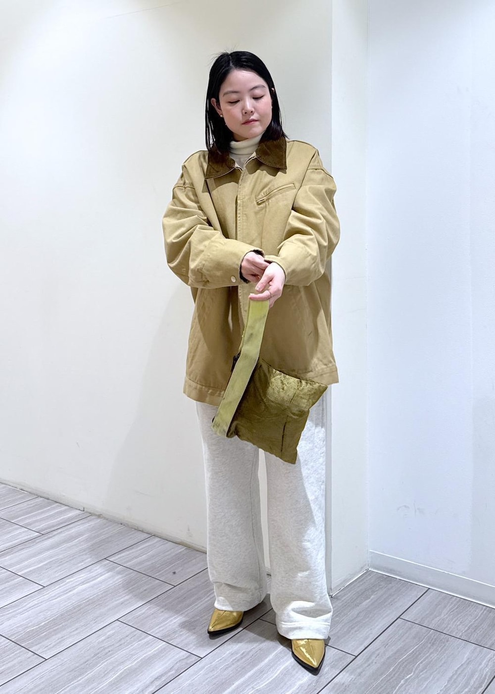 ゴールド系のブーツ、ホワイト系のスウェットパンツ、ベージュ系のその他アウターを着用したレディースの冬コーディネートの7枚目の写真