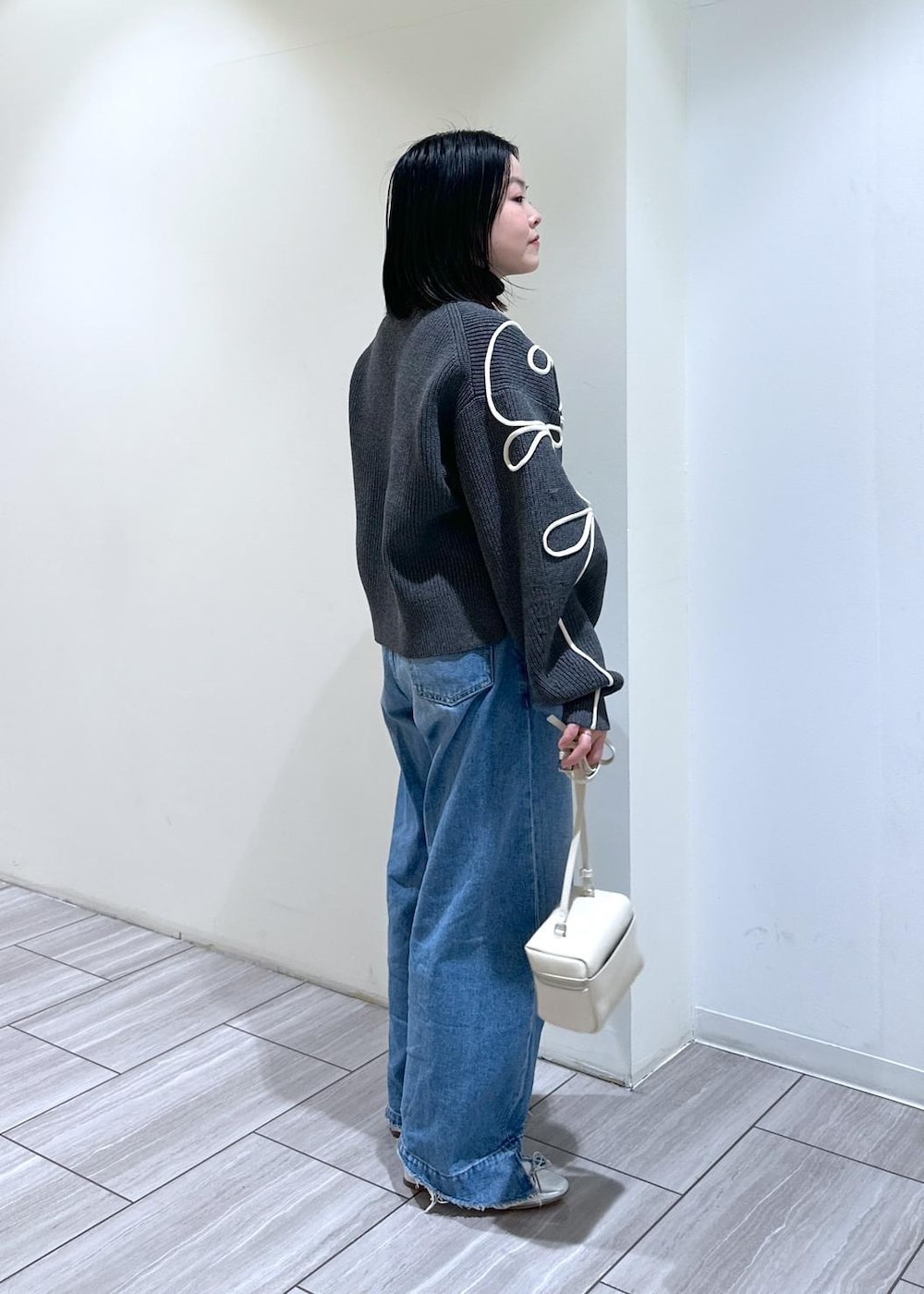 グレー系のカーディガン/ボレロ、ホワイト系のショルダーバッグ、シルバー系のバレエシューズを着用したレディースの冬コーディネートの4枚目の写真