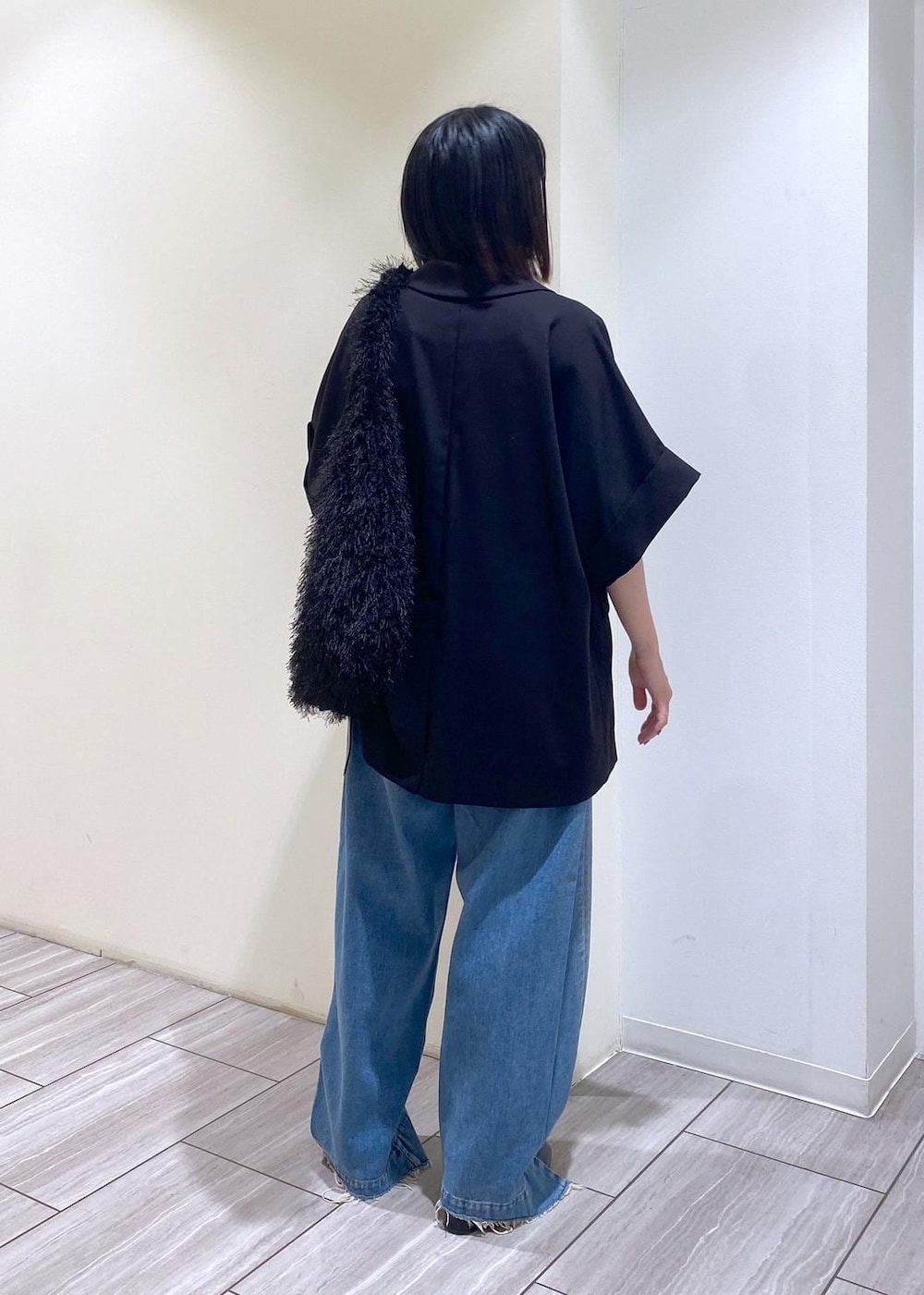 ブルー系のデニムパンツ、ブラック系のテーラードジャケット、ブラック系のパンプスを着用したレディースの夏コーディネートの3枚目の写真
