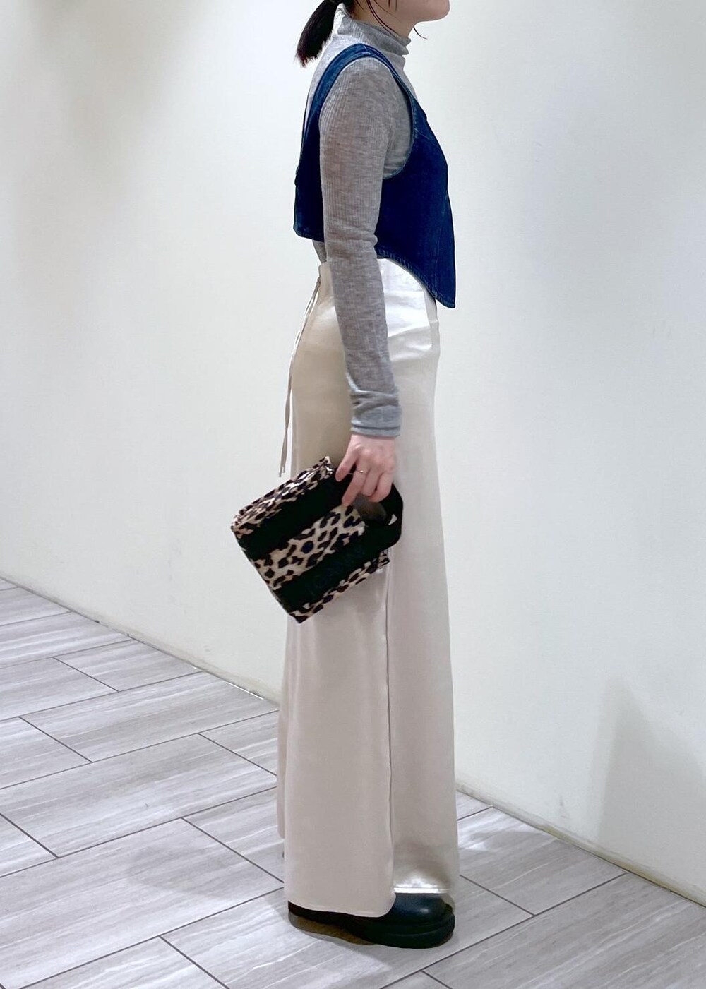 ベージュ系のトートバッグ、ブラック系のブーツ、ホワイト系のスカートを着用したレディースの秋コーディネートの9枚目の写真