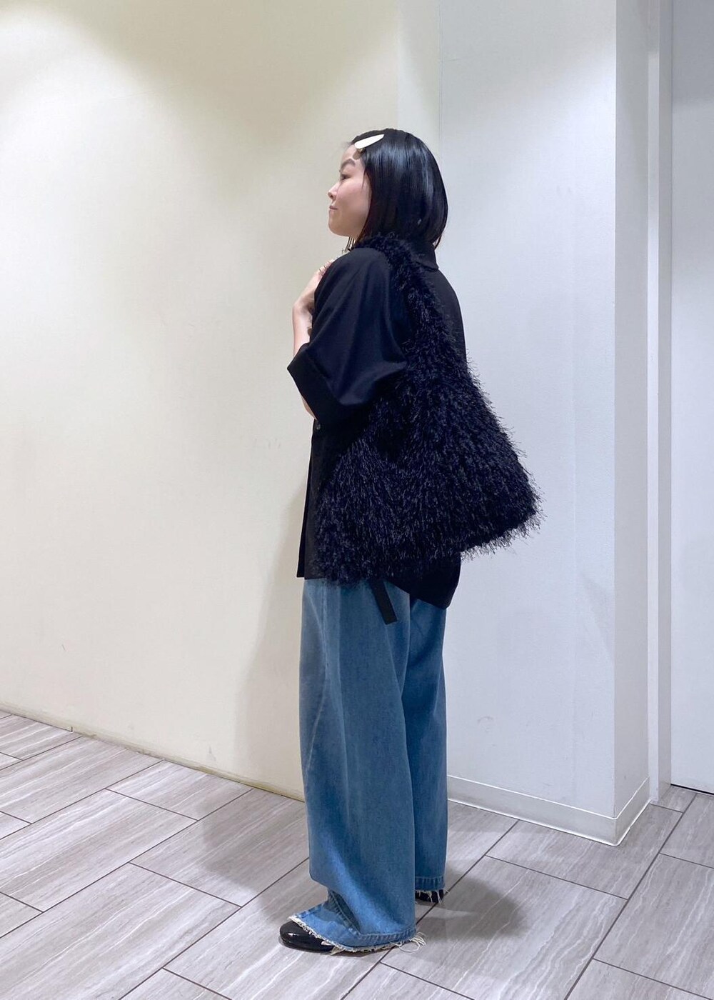 ブルー系のデニムパンツ、ブラック系のテーラードジャケット、ブラック系のパンプスを着用したレディースの夏コーディネートの2枚目の写真