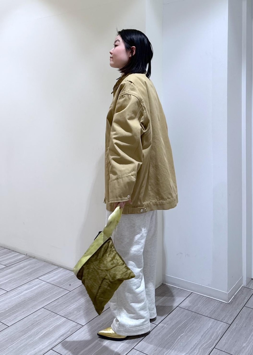 ゴールド系のブーツ、ホワイト系のスウェットパンツ、ベージュ系のその他アウターを着用したレディースの冬コーディネートの2枚目の写真