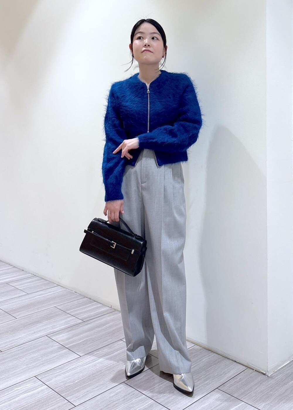 シルバー系のブーツ、ブルー系のカーディガン/ボレロ、グレー系のスラックスを着用したレディースの秋コーディネートの4枚目の写真