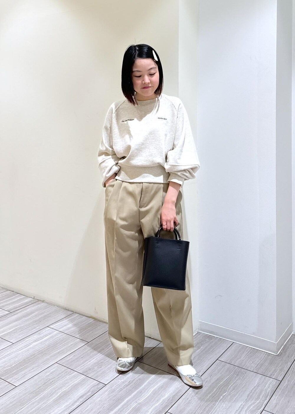 ブラック系のショルダーバッグ、シルバー系のバレエシューズ、ベージュ系のスラックスを着用したレディースの秋コーディネートの5枚目の写真