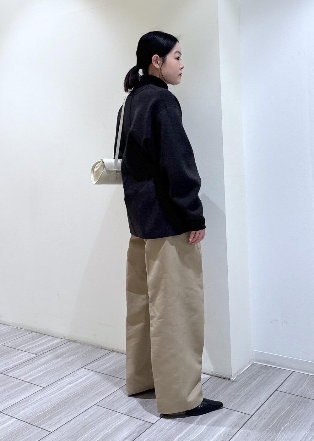 ブラック系のパンプス、グレー系のカーディガン/ボレロ、ホワイト系のショルダーバッグを着用したレディースの冬コーディネートの6枚目の写真