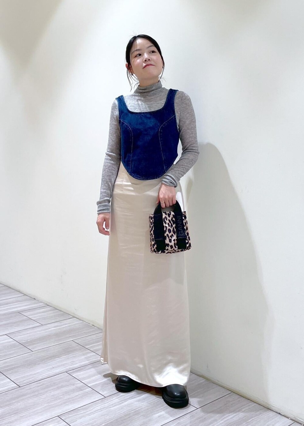 ベージュ系のトートバッグ、ブラック系のブーツ、ホワイト系のスカートを着用したレディースの秋コーディネートの7枚目の写真