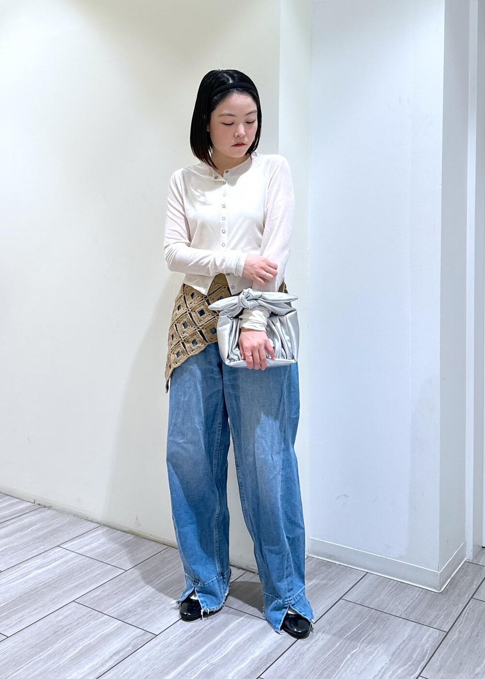 ブルー系のデニムパンツ、シルバー系のショルダーバッグ、ブラック系のパンプスを着用したレディースの秋コーディネートの5枚目の写真