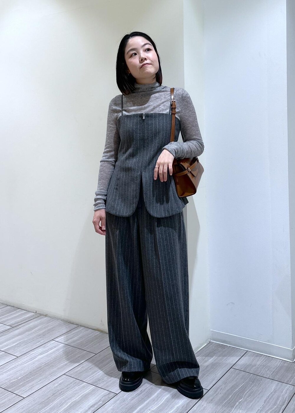 グレー系のキャミソール、グレー系のニット/セーター、グレー系のスラックスを着用したレディースの秋コーディネートの4枚目の写真