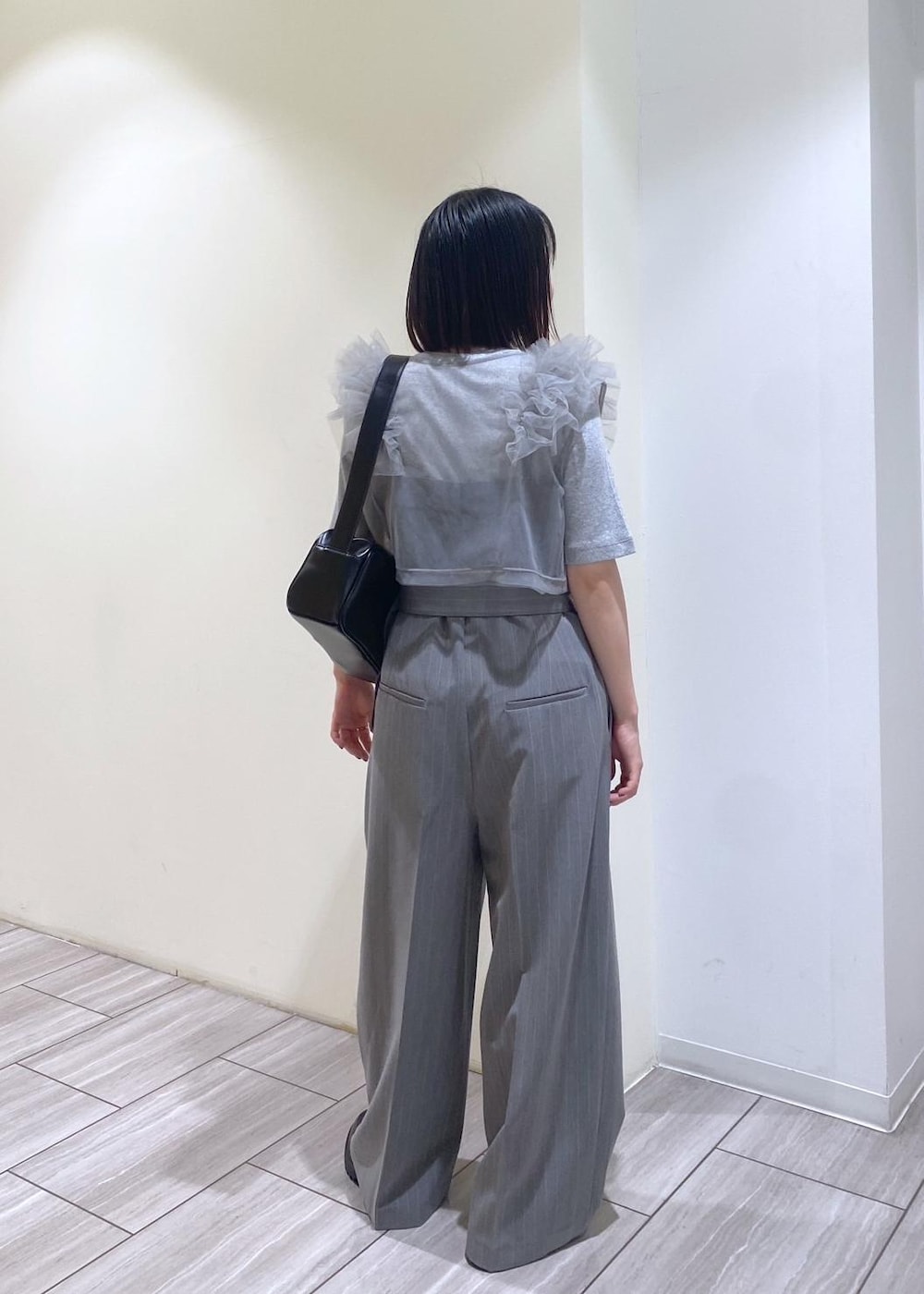 ブラック系のローファー、グレー系のTシャツ/カットソー、ブラック系のショルダーバッグを着用したレディースの夏コーディネートの3枚目の写真