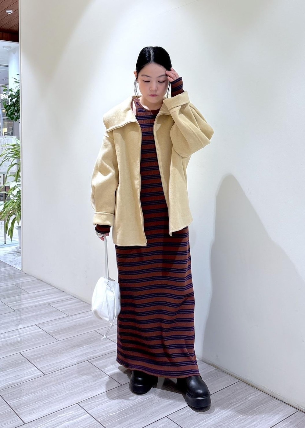 ブラック系のサンダル、ホワイト系のハンドバッグ、ブラウン系のワンピースを着用したレディースの秋コーディネートの2枚目の写真