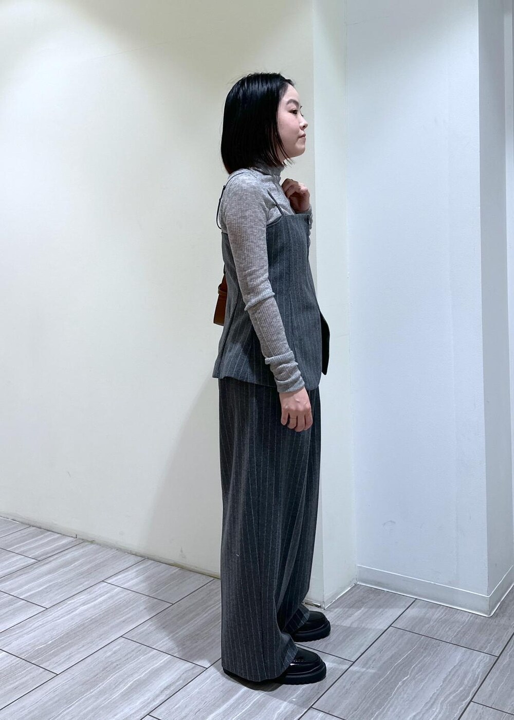 グレー系のキャミソール、グレー系のニット/セーター、グレー系のスラックスを着用したレディースの秋コーディネートの3枚目の写真