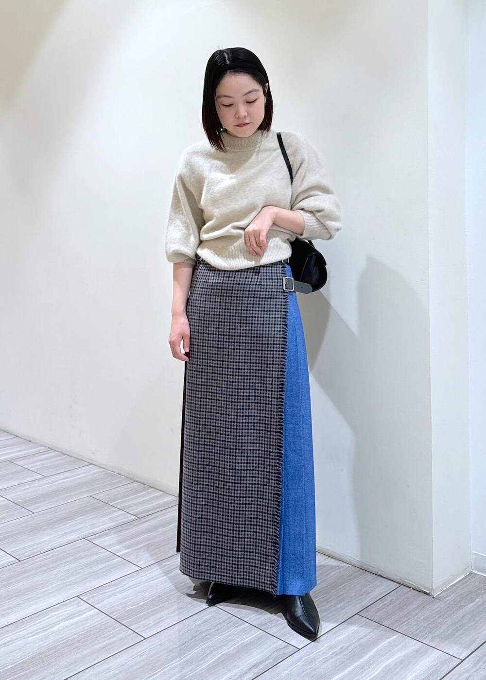 ブラック系のブーツ、ブラック系のショルダーバッグ、ホワイト系のニット/セーターを着用したレディースの秋コーディネートの5枚目の写真