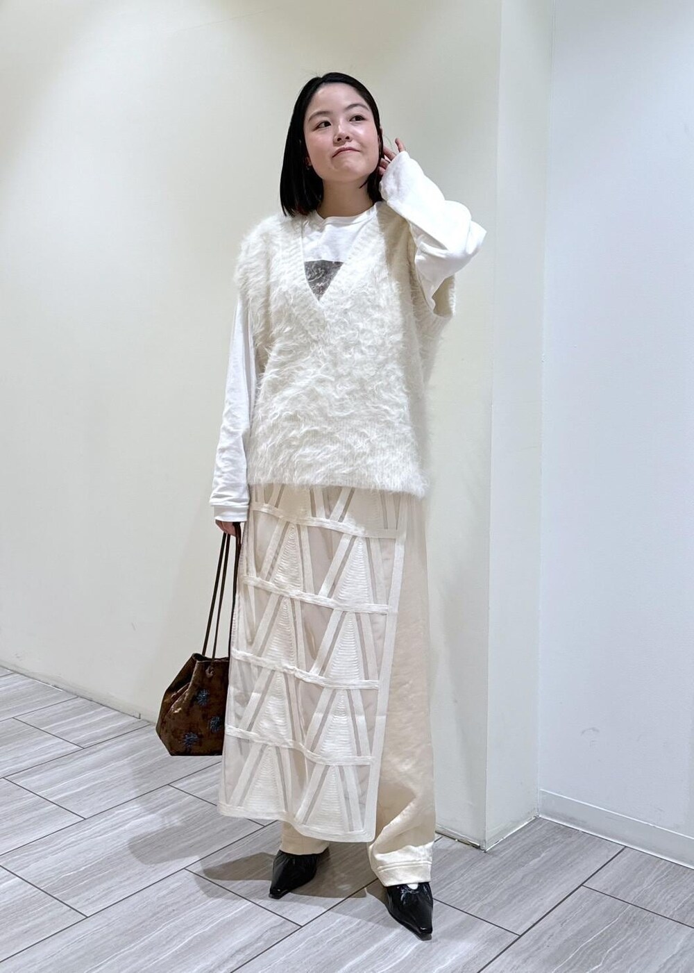 ブラック系のパンプス、ホワイト系のスカート、ホワイト系のニット/セーターを着用したレディースの秋コーディネートの5枚目の写真