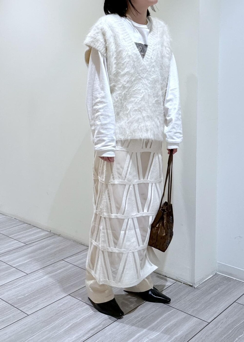 ブラック系のパンプス、ホワイト系のスカート、ホワイト系のニット/セーターを着用したレディースの秋コーディネートの6枚目の写真