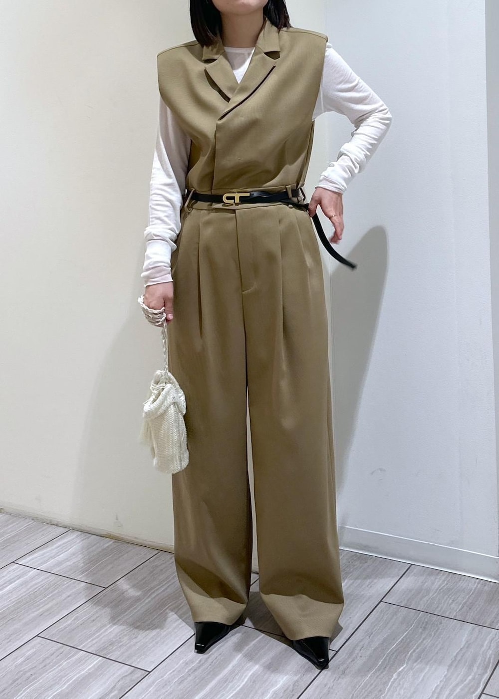 ホワイト系のショルダーバッグ、ベージュ系のサロペット/オーバーオール、ブラック系のパンプスを着用したレディースの秋コーディネートの5枚目の写真