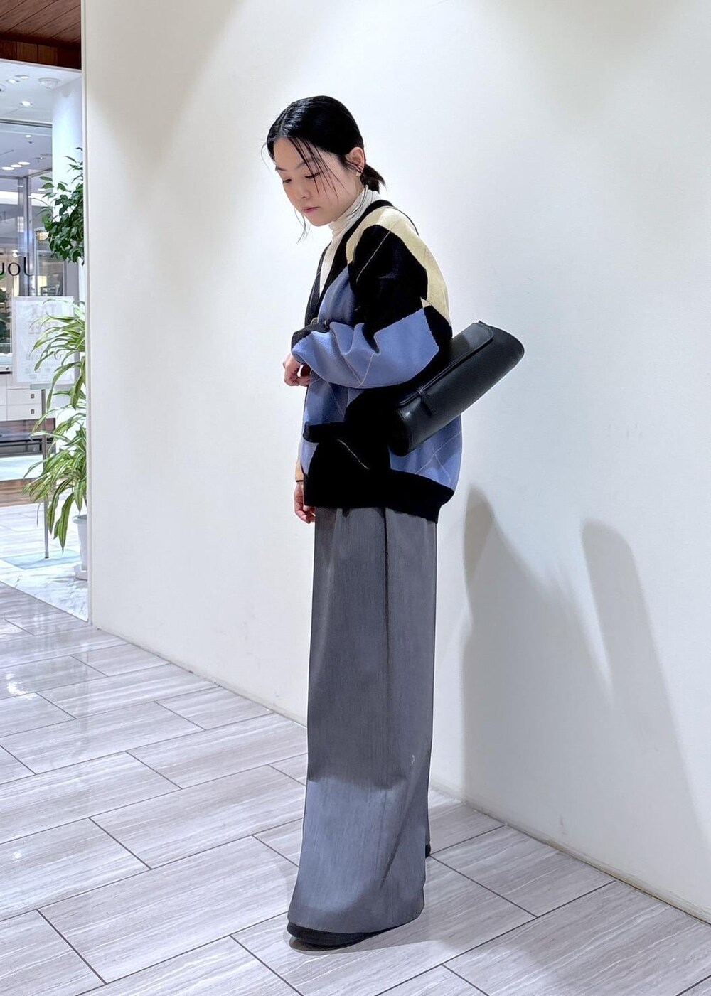 ブラック系のサンダル、ブラック系のショルダーバッグ、ホワイト系のニット/セーターを着用したレディースの秋コーディネートの3枚目の写真