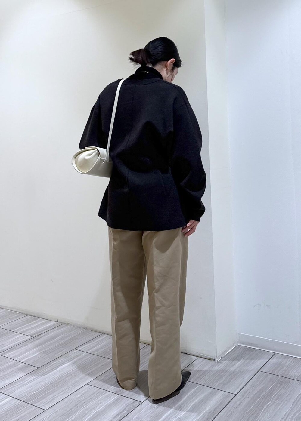 ブラック系のパンプス、グレー系のカーディガン/ボレロ、ホワイト系のショルダーバッグを着用したレディースの冬コーディネートの5枚目の写真