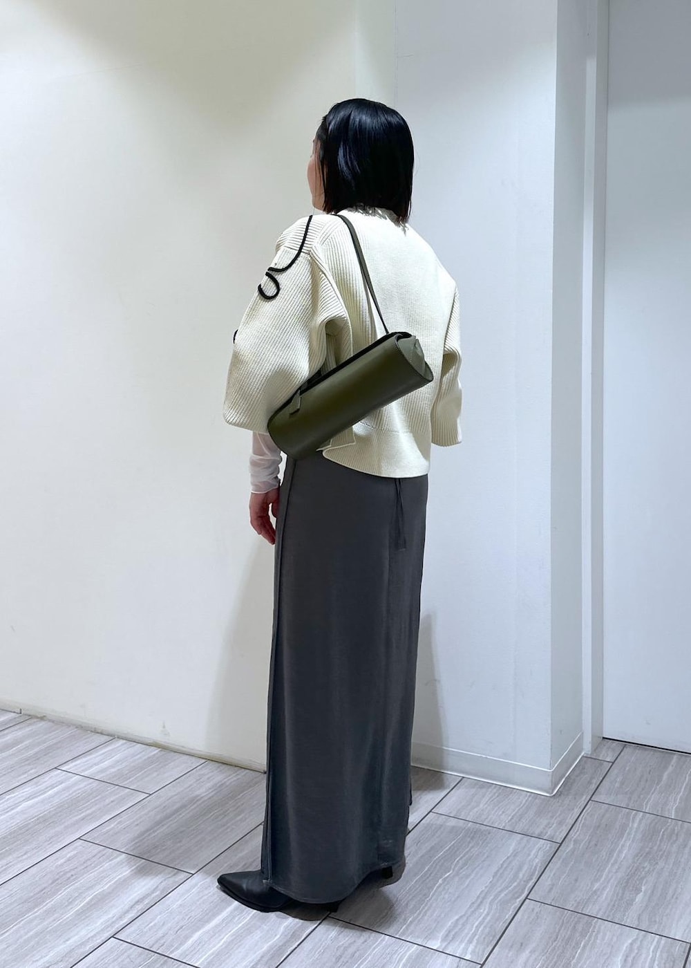 ホワイト系のカーディガン/ボレロ、ブラック系のブーツ、ホワイト系のTシャツ/カットソーを着用したレディースの秋コーディネートの3枚目の写真