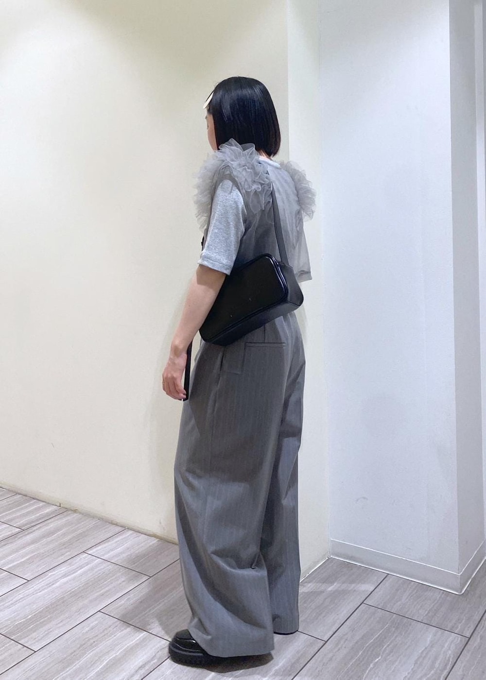 ブラック系のローファー、グレー系のTシャツ/カットソー、ブラック系のショルダーバッグを着用したレディースの夏コーディネートの2枚目の写真