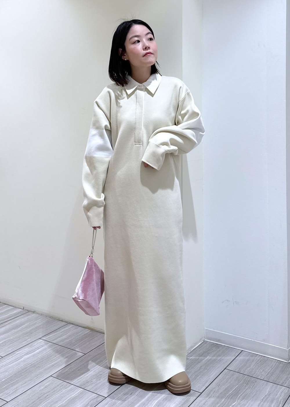 ベージュ系のブーツ、ホワイト系のブルゾン、ホワイト系のワンピースを着用したレディースの冬コーディネートの2枚目の写真