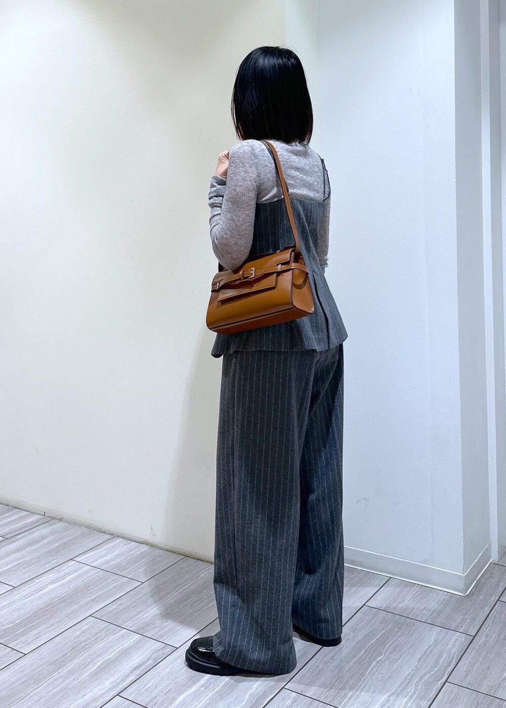 グレー系のキャミソール、グレー系のニット/セーター、グレー系のスラックスを着用したレディースの秋コーディネートの2枚目の写真