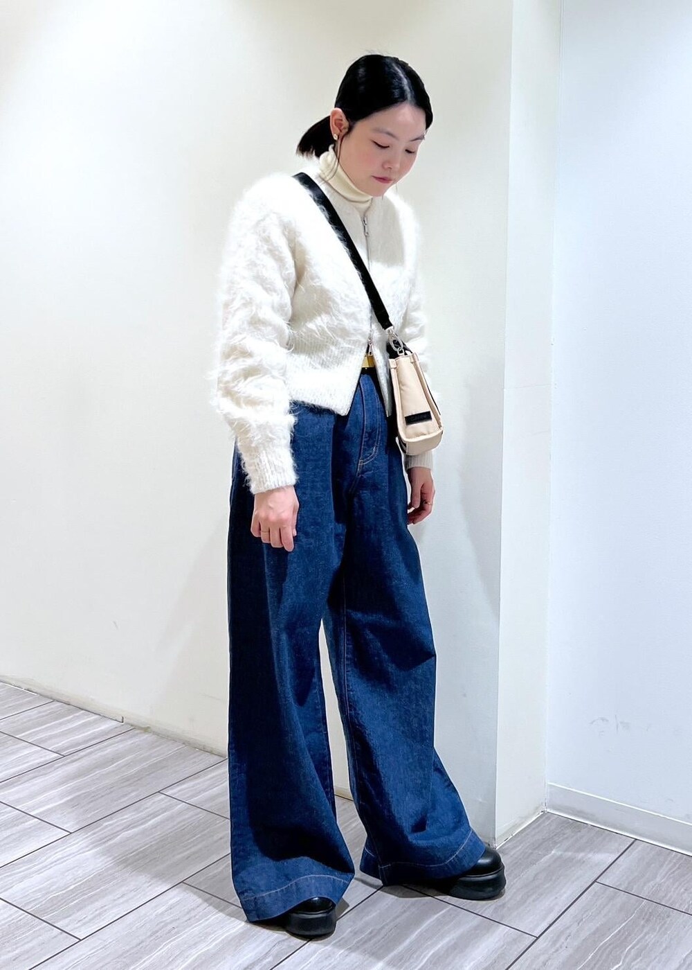 ベージュ系のトートバッグ、ブラック系のサンダル、ホワイト系のカーディガン/ボレロを着用したレディースの冬コーディネートの6枚目の写真