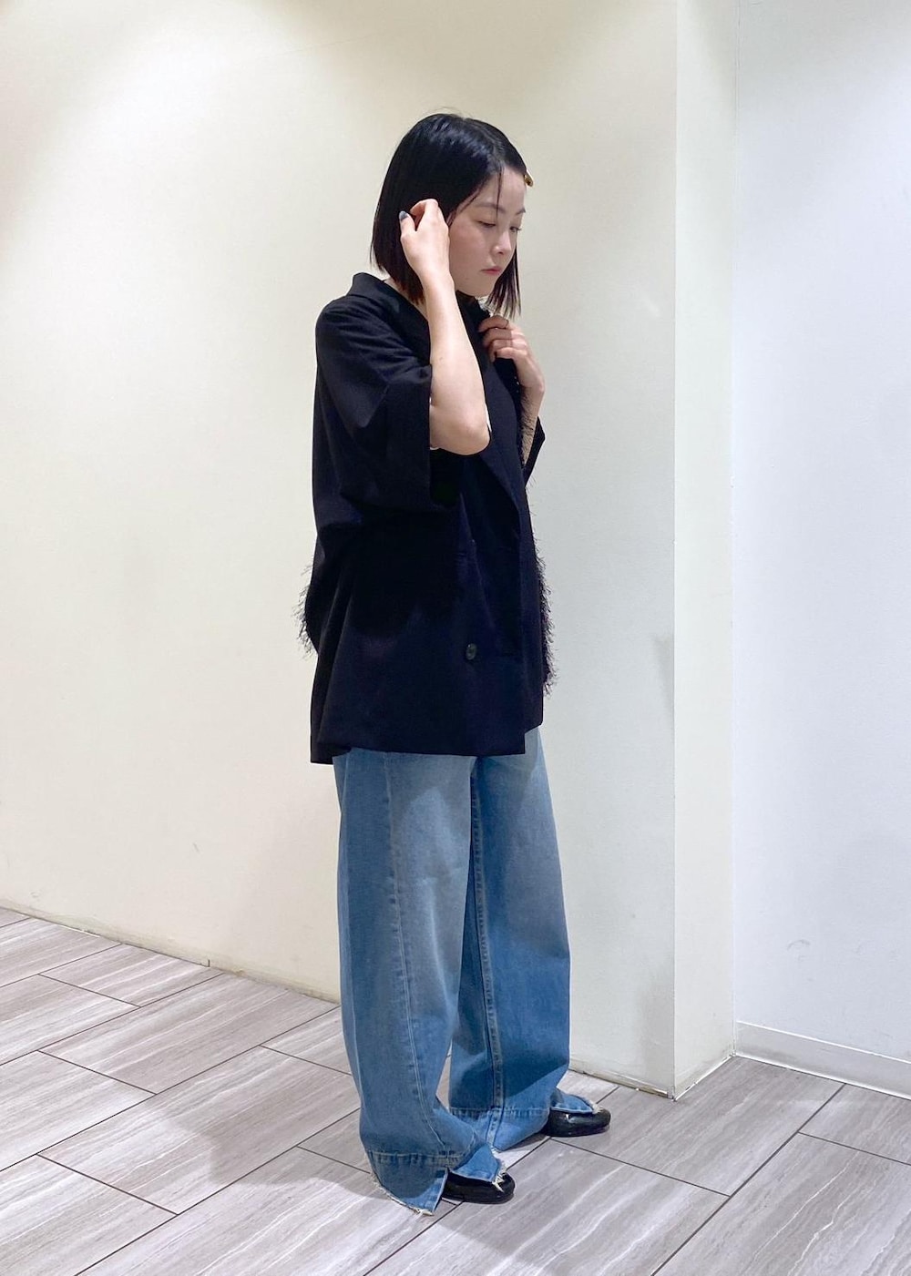 ブルー系のデニムパンツ、ブラック系のテーラードジャケット、ブラック系のパンプスを着用したレディースの夏コーディネートの4枚目の写真