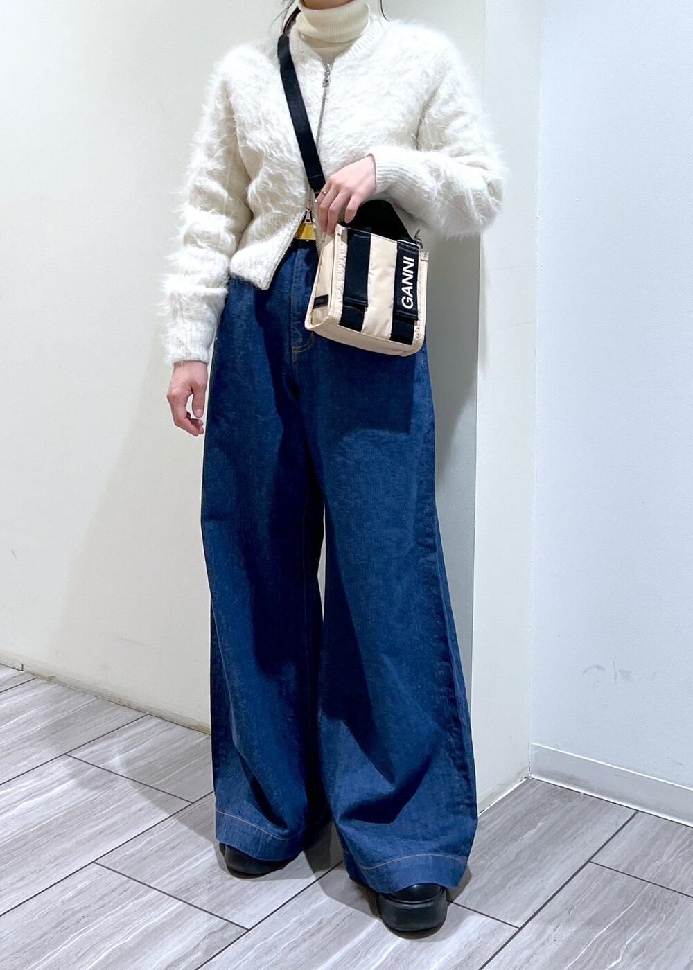 ベージュ系のトートバッグ、ブラック系のサンダル、ホワイト系のカーディガン/ボレロを着用したレディースの冬コーディネートの7枚目の写真