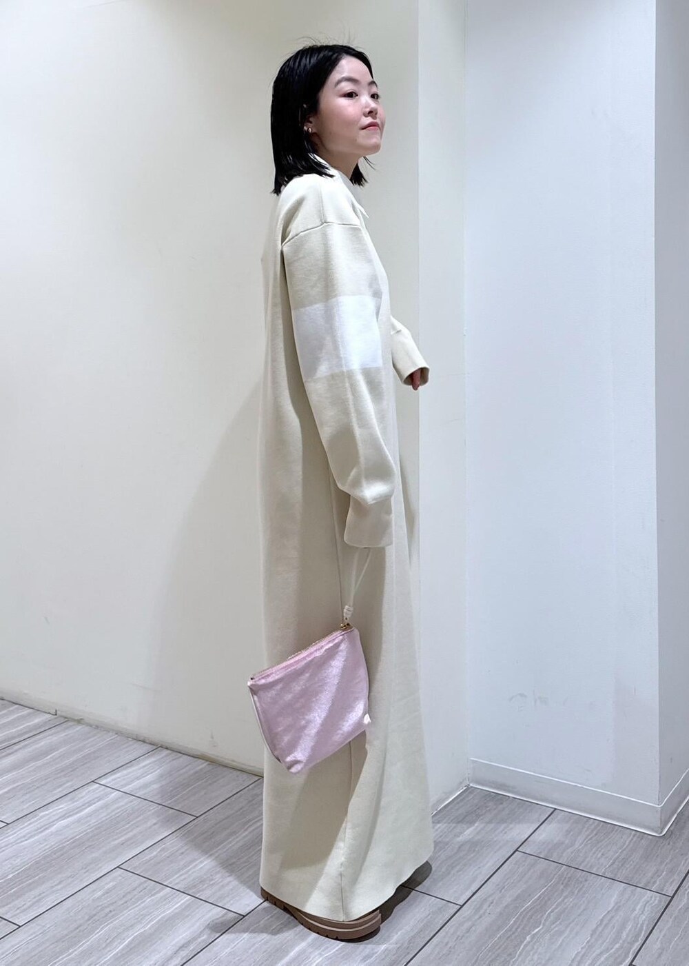 ベージュ系のブーツ、ホワイト系のブルゾン、ホワイト系のワンピースを着用したレディースの冬コーディネートの7枚目の写真