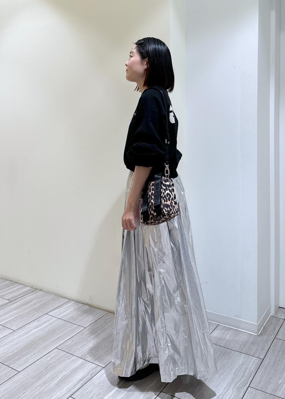 ベージュ系のサンダル、ベージュ系のトートバッグ、シルバー系のスカートを着用したレディースの秋コーディネートの2枚目の写真