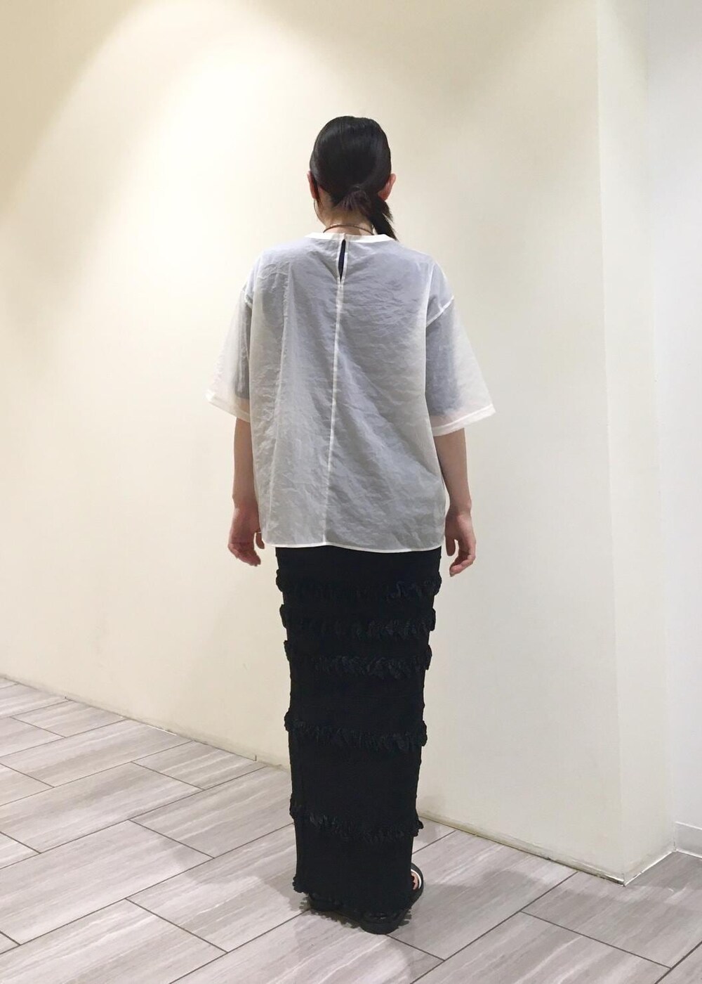 ブラック系のサンダル、ホワイト系のTシャツ/カットソー、ブラック系のスカートを着用したレディースの夏コーディネートの3枚目の写真