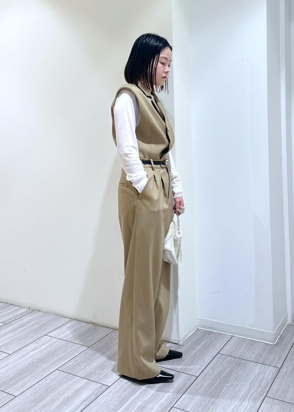 ホワイト系のショルダーバッグ、ベージュ系のサロペット/オーバーオール、ブラック系のパンプスを着用したレディースの秋コーディネートの3枚目の写真
