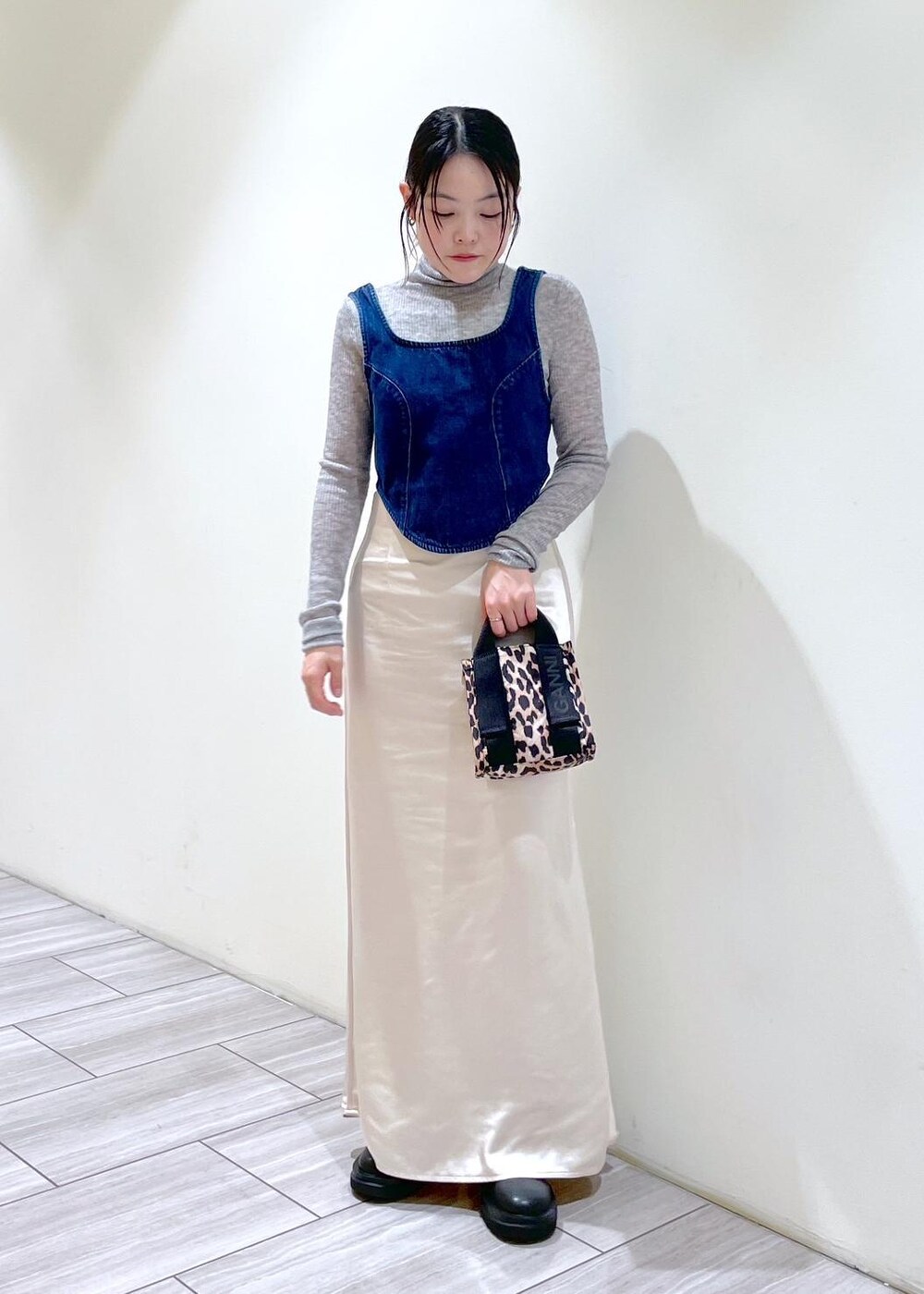 ベージュ系のトートバッグ、ブラック系のブーツ、ホワイト系のスカートを着用したレディースの秋コーディネートの8枚目の写真