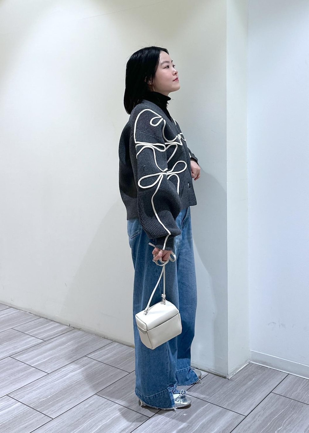 グレー系のカーディガン/ボレロ、ホワイト系のショルダーバッグ、シルバー系のバレエシューズを着用したレディースの冬コーディネートの5枚目の写真