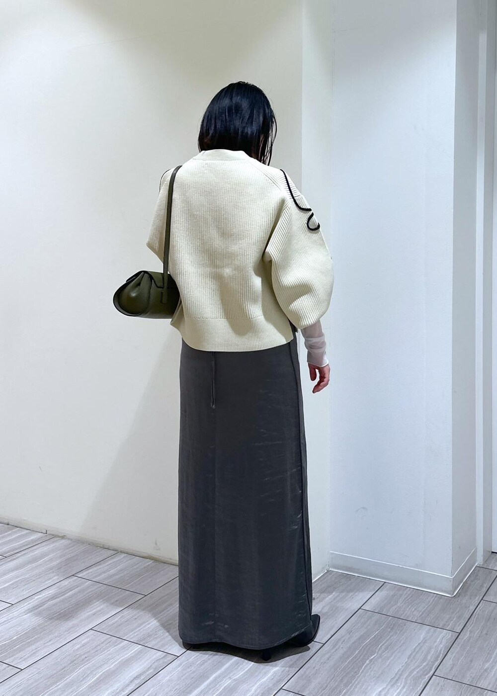 ホワイト系のカーディガン/ボレロ、ブラック系のブーツ、ホワイト系のTシャツ/カットソーを着用したレディースの秋コーディネートの4枚目の写真