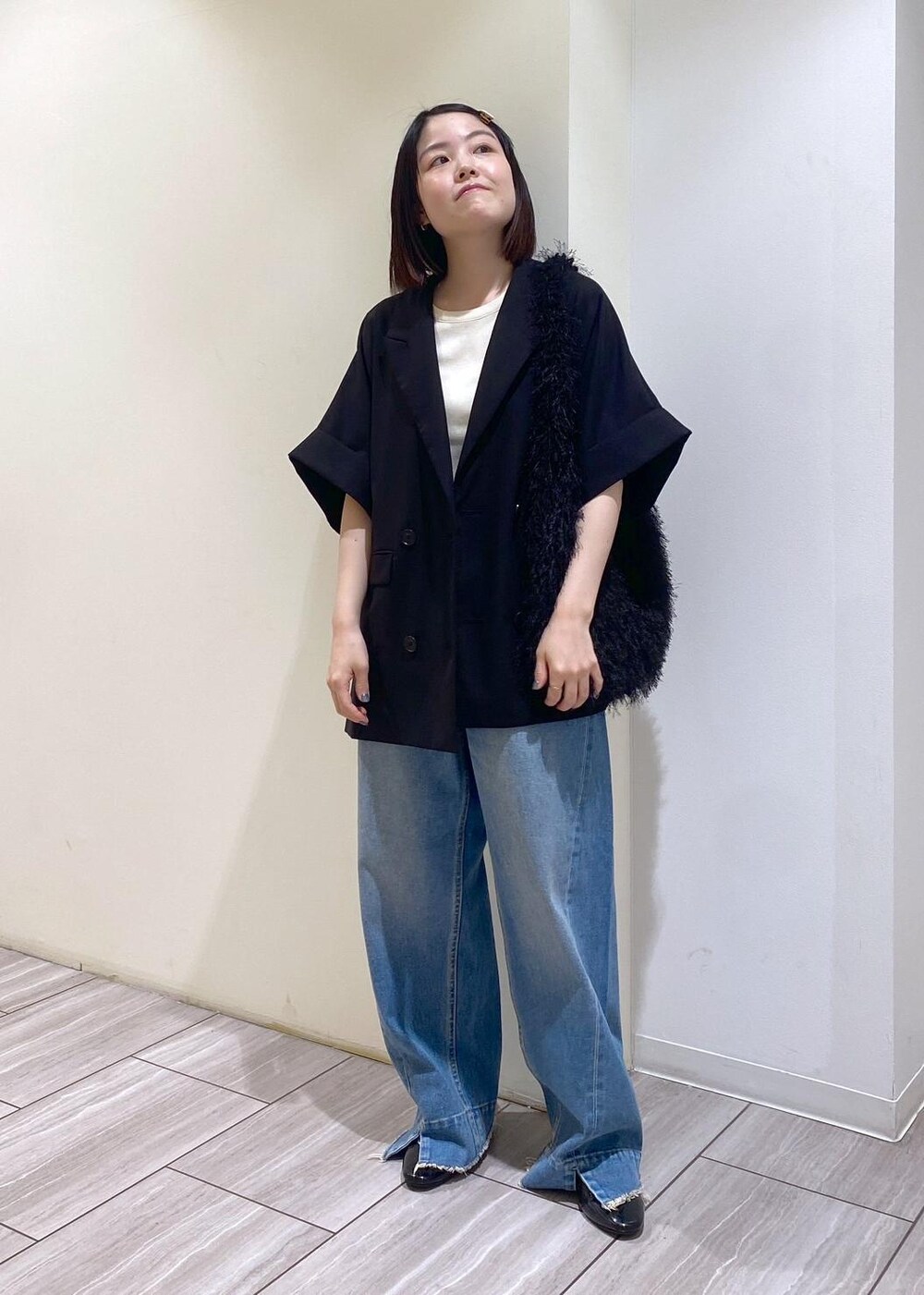 ブルー系のデニムパンツ、ブラック系のテーラードジャケット、ブラック系のパンプスを着用したレディースの夏コーディネートの5枚目の写真