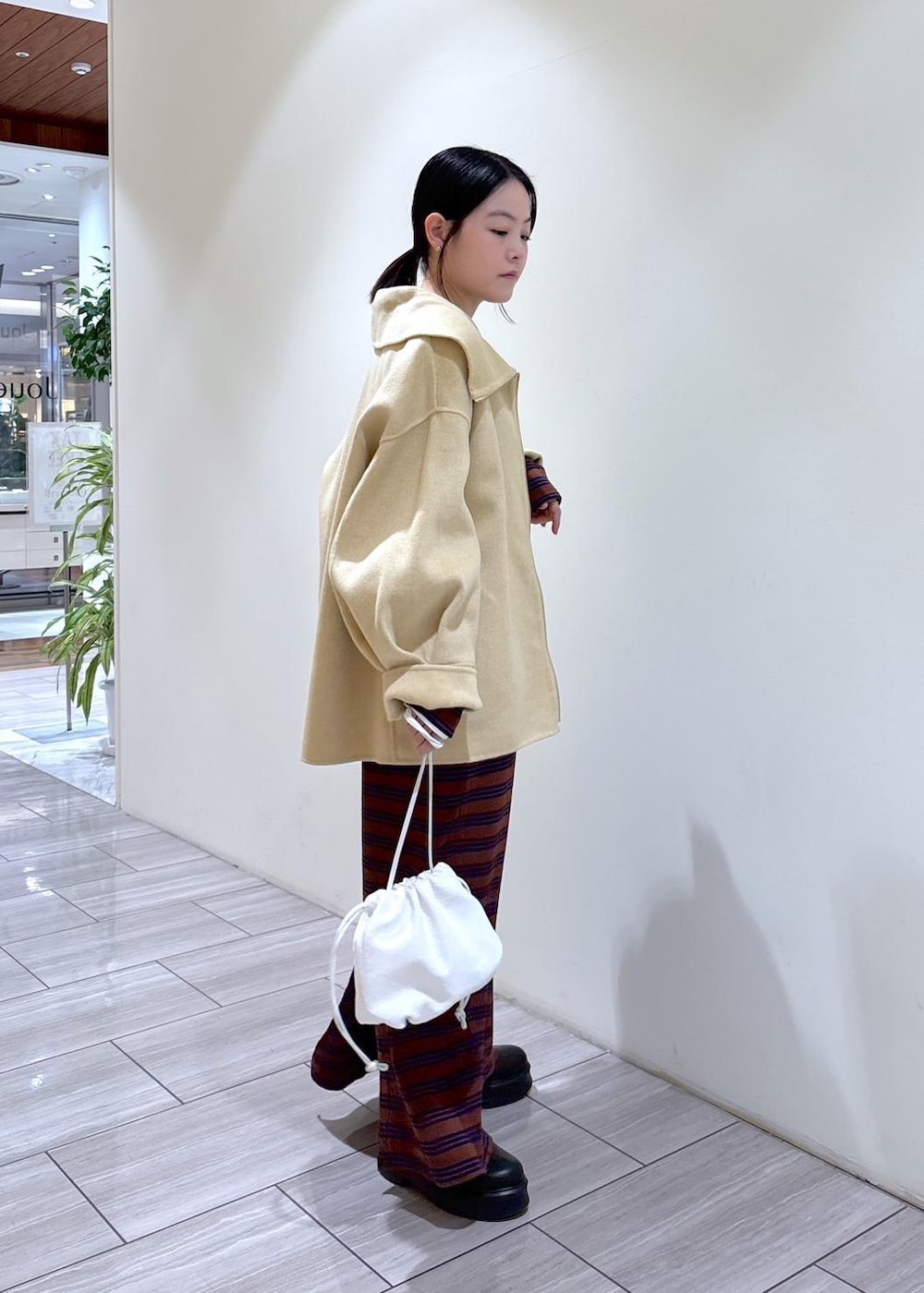 ブラック系のサンダル、ホワイト系のハンドバッグ、ブラウン系のワンピースを着用したレディースの秋コーディネートの4枚目の写真