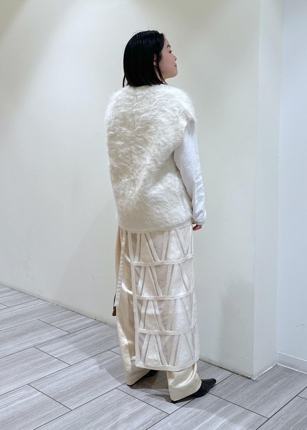 ブラック系のパンプス、ホワイト系のスカート、ホワイト系のニット/セーターを着用したレディースの秋コーディネートの4枚目の写真