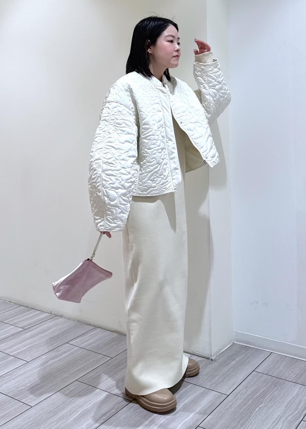 ベージュ系のブーツ、ホワイト系のブルゾン、ホワイト系のワンピースを着用したレディースの冬コーディネートの3枚目の写真