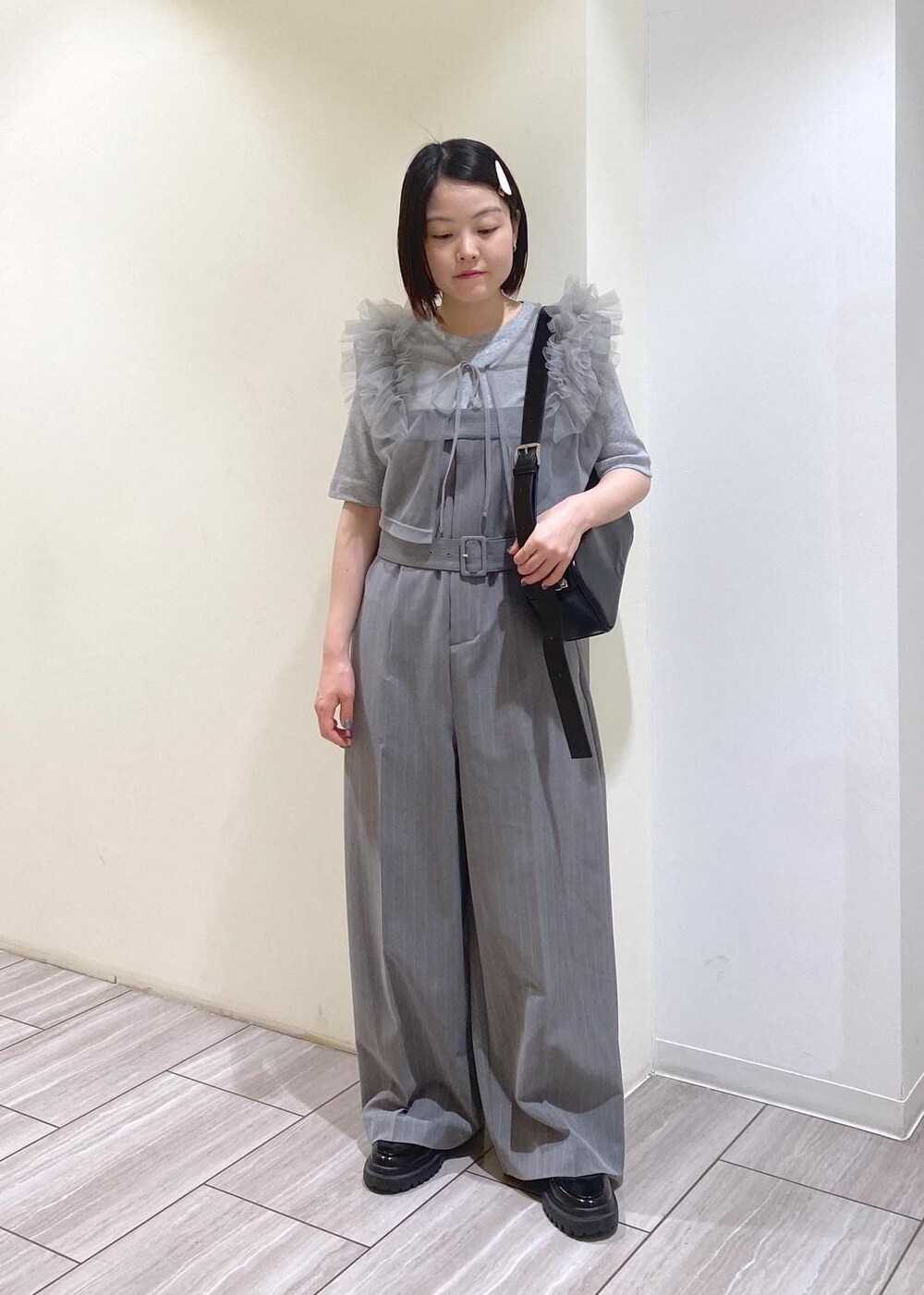 ブラック系のローファー、グレー系のTシャツ/カットソー、ブラック系のショルダーバッグを着用したレディースの夏コーディネートの5枚目の写真