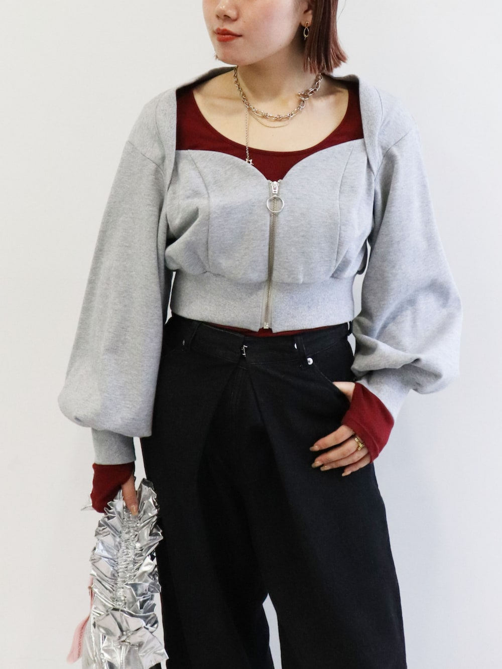 シルバー系のショルダーバッグ、グレー系のスウェットを着用したレディースの冬コーディネートの2枚目の写真