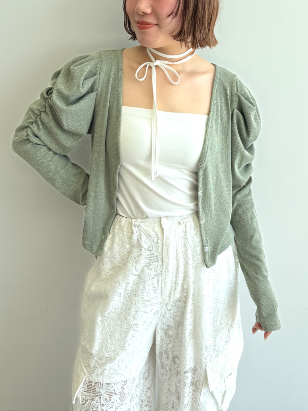 ホワイト系のカーゴパンツ、イエロー系のワンピースを着用したレディースの春コーディネートの2枚目の写真