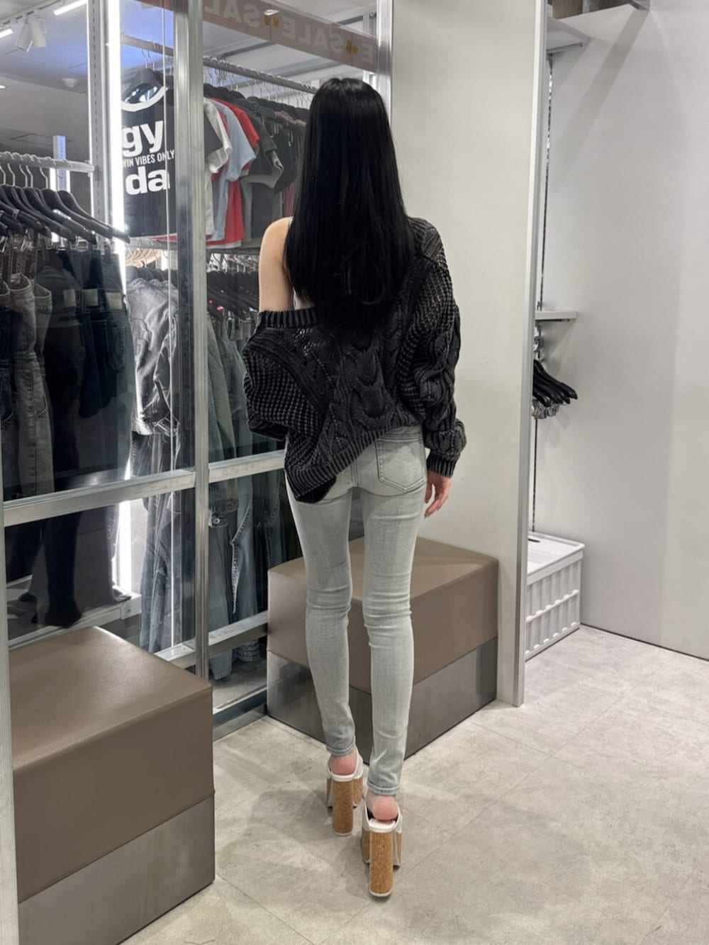ホワイト系のサンダル、ブルー系のデニムパンツ、ホワイト系のキャミソールを着用したレディースの夏コーディネートの3枚目の写真
