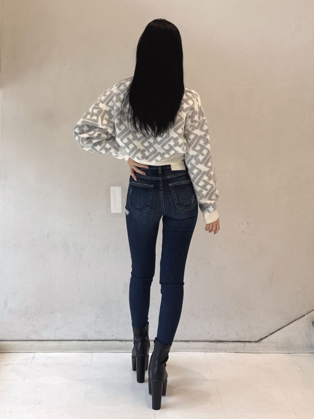 ブラック系のブーツ、ホワイト系のニット/セーター、ブルー系のデニムパンツを着用したレディースの冬コーディネートの3枚目の写真